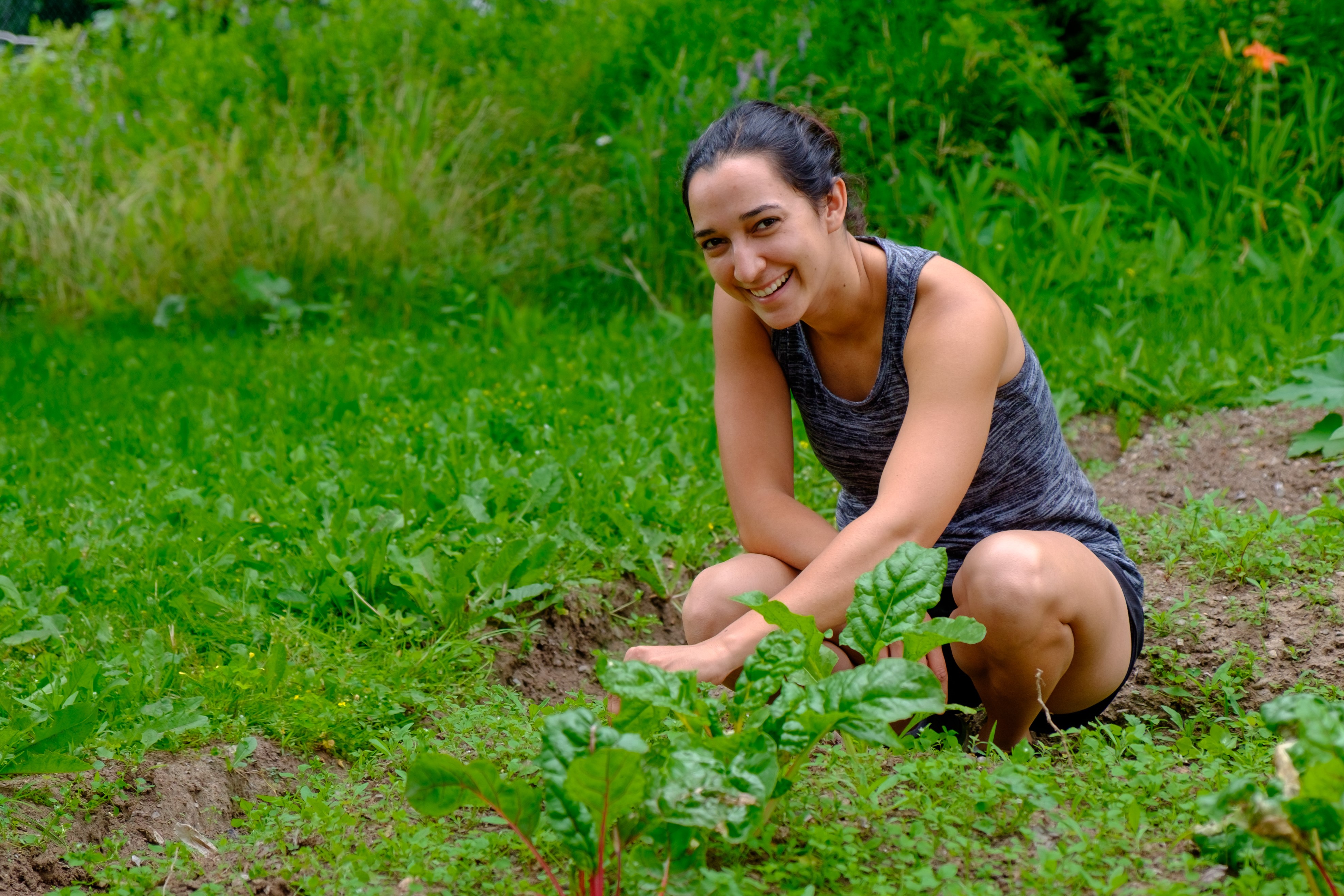 woman smiling and digging in garden